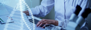 The image depicts a scientist working with digital genetic data. In the foreground, a graphical representation of a DNA double helix is superimposed over the scene, indicating the genetic focus of the work. The scientist, wearing a lab coat, is engaged with a tablet, likely analyzing data or controlling laboratory equipment. The overall blue tone of the image conveys a high-tech, clinical atmosphere.